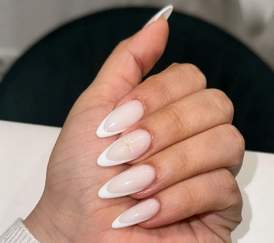 Uñas almendra en francesa blanca con estrella dorada