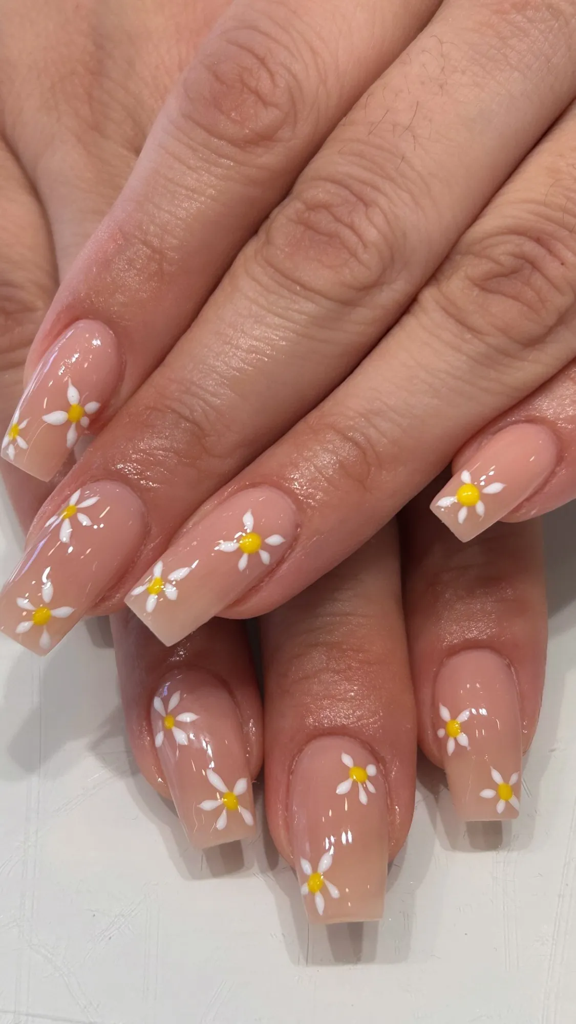 Uñas nude con margaritas pintadas a mano